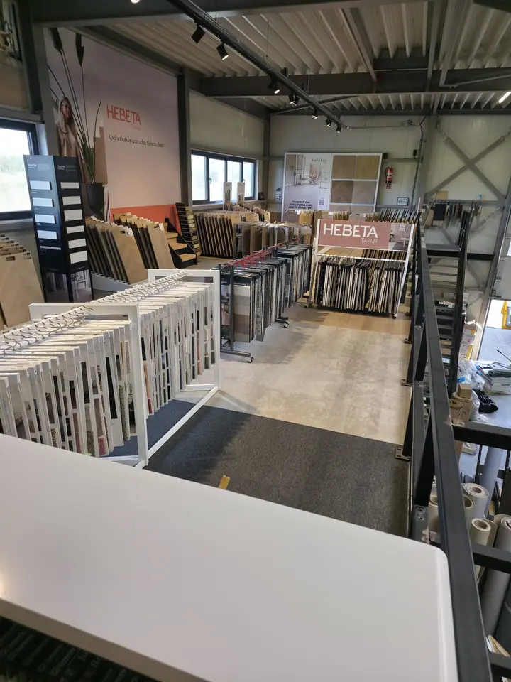 Rijen stalenrekken met vloeren in de showroom van Hello Floor