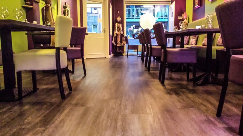 Restaurant met paarse stoelen op een houtlook PVC-vloer