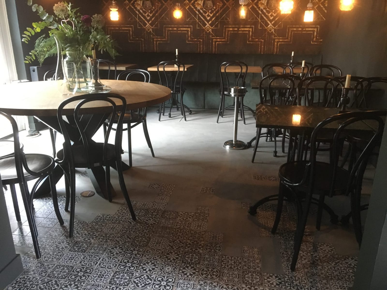Sfeervol restaurant met bar en een vloer in cementtegel-look