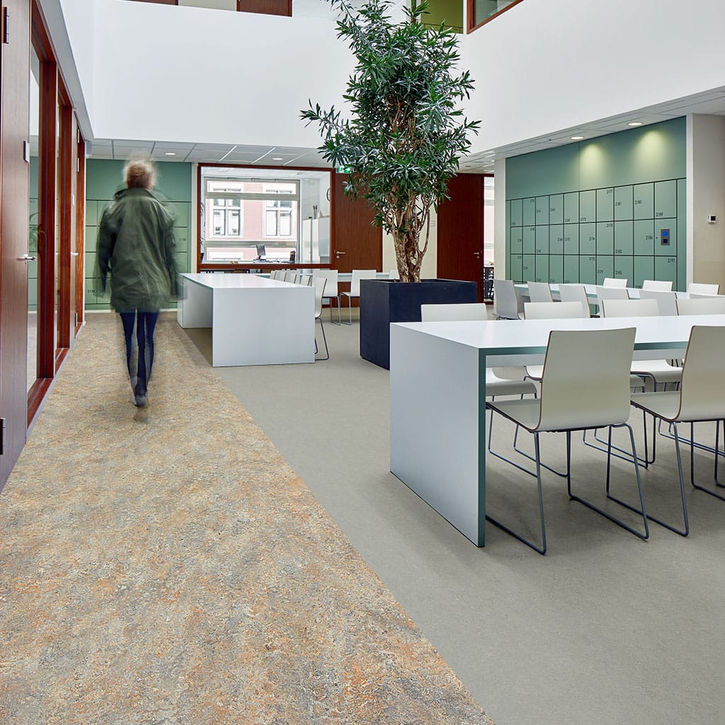 Gemêleerde marmoleumvloer in een kantine met witte tafels