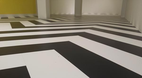 Zwarte en witte PVC-stroken in zigzagpatroon in de nog lege winkel van Hearts Amsterdam