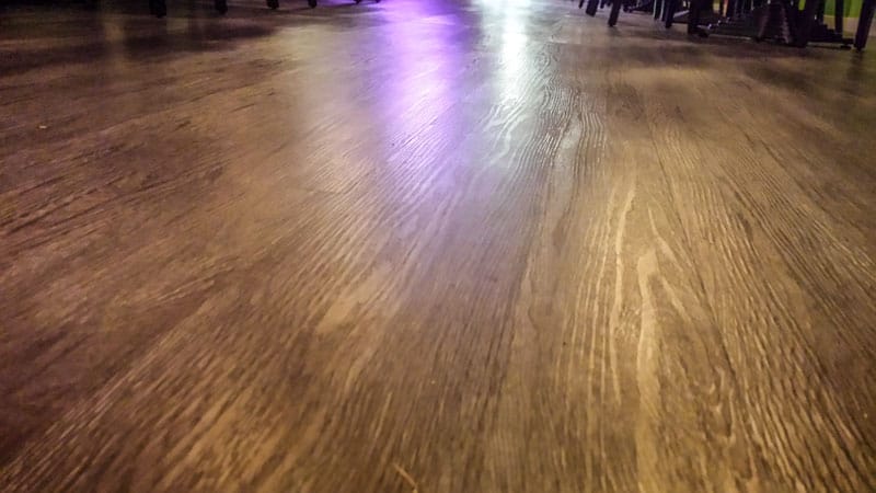 Donkere houtlook PVC-vloer in de eetzaal van Thais restaurant Lemon Leaf, van dichtbij gezien