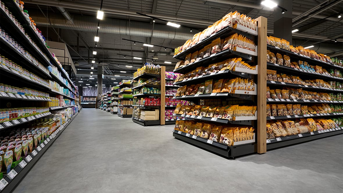 Grijze rubbervloer in het gangpad van een supermarkt