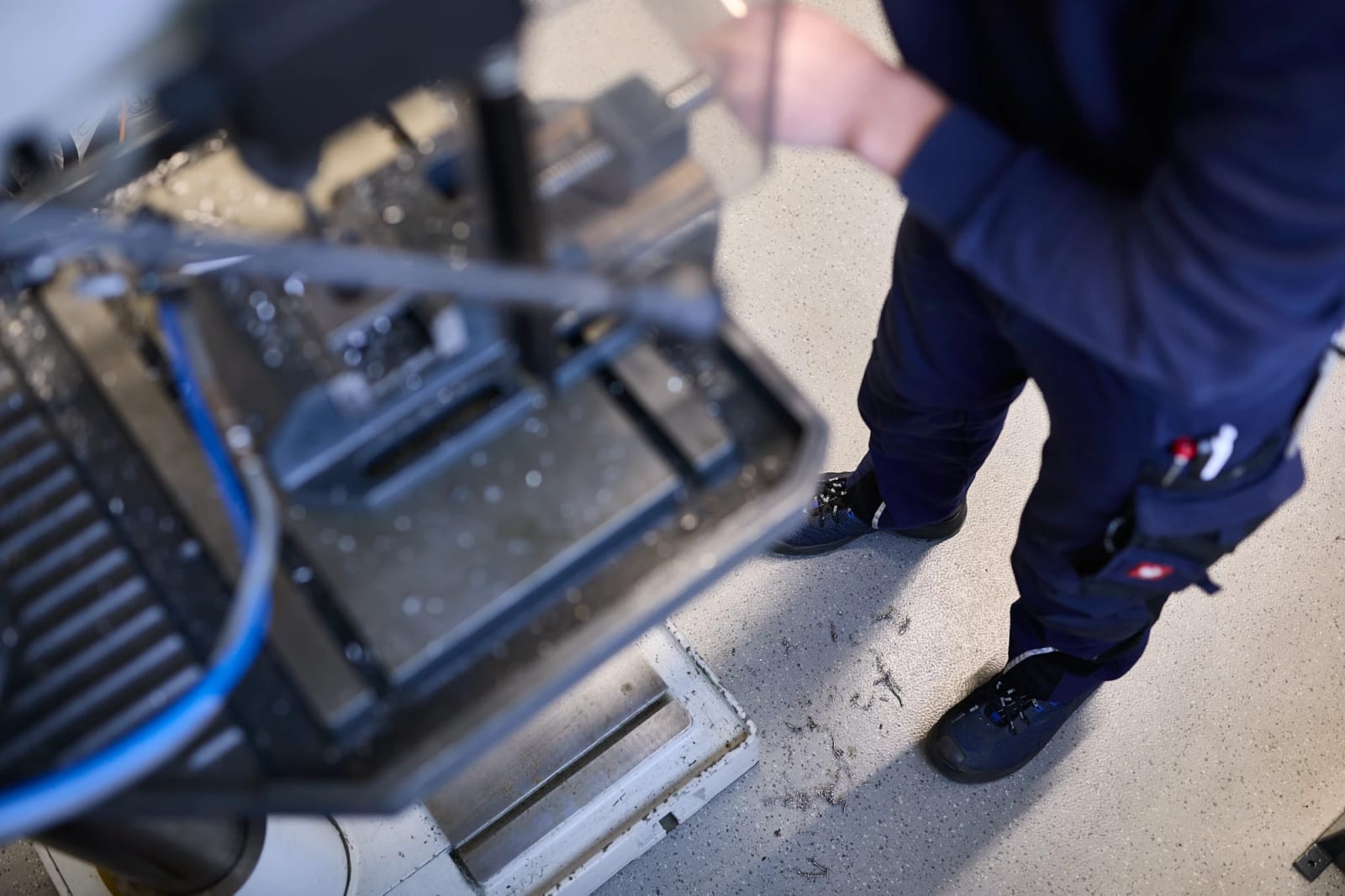 Medewerker bij een kolomboormachine op een lichte rubbervloer met spikkels